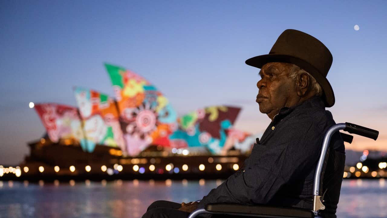 Artist and Pitjantjatjara man Yadjidta David Miller looks on as his artwork is projected onto the sails of the Sydney Opera House at dawn during Australia Day 2022 celebrations, in Sydney, Wednesday, January 26, 2022 (AAP Image/Bianca De Marchi) NO ARCHIV