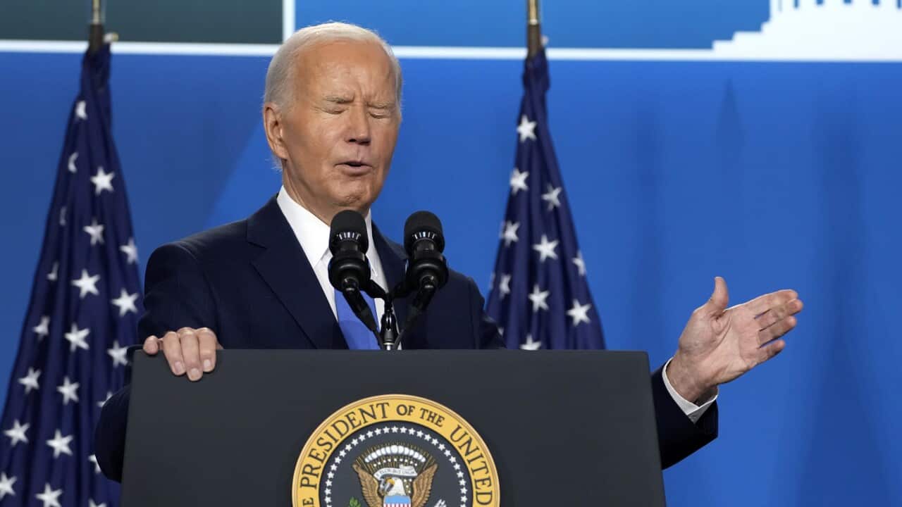 US President Joe Biden standing at a lectern speaking in front of microphones.