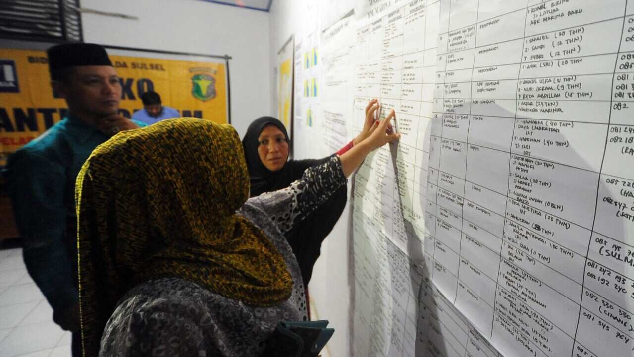 Indonesian relatives check the passengers board of a capsized ferry at a crisis center in Siwa, Wajo, South Sulawesi, Indonesia, 20 December 2015.