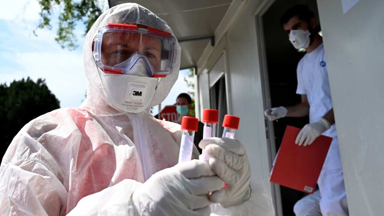 A medical staff holds test tubes with swab samples at a drive-through COVID-19 test centre on August 17, 2020, in Zagreb