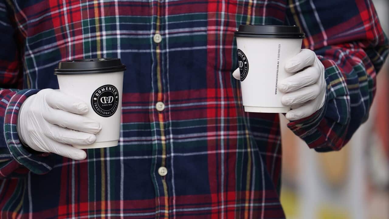 A member of the public is seen wearing gloves while leaving a cafe in Brunswick, Melbourne, Tuesday, March 24, 2020. (AAP Image/Stefan Postles) NO ARCHIVING