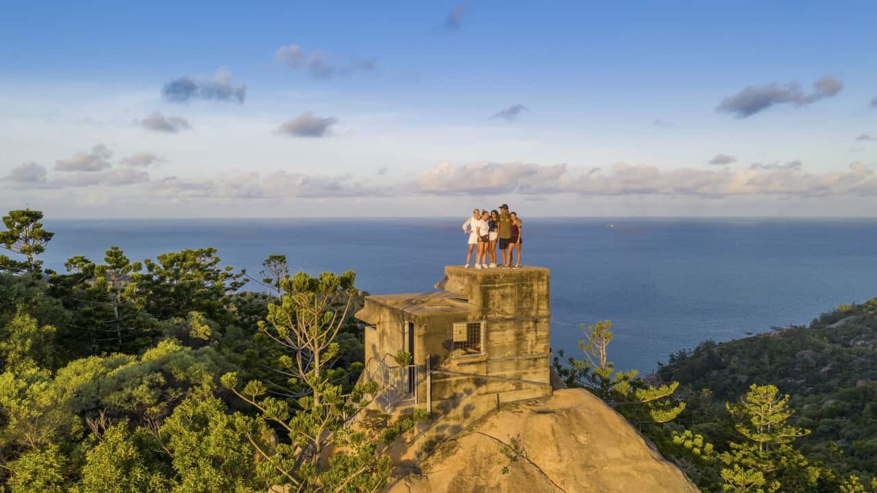 Travelers climb a historic WW2 fortification for sunset views.