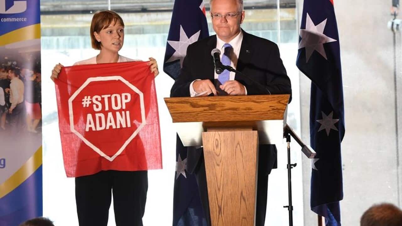 A Stop Adani protestor gets on to the stage where PM is speaking