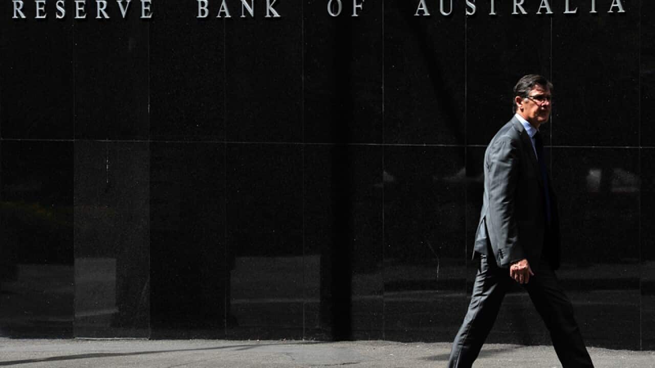 Pedestrians walk past the Reserve Bank of Australia head office