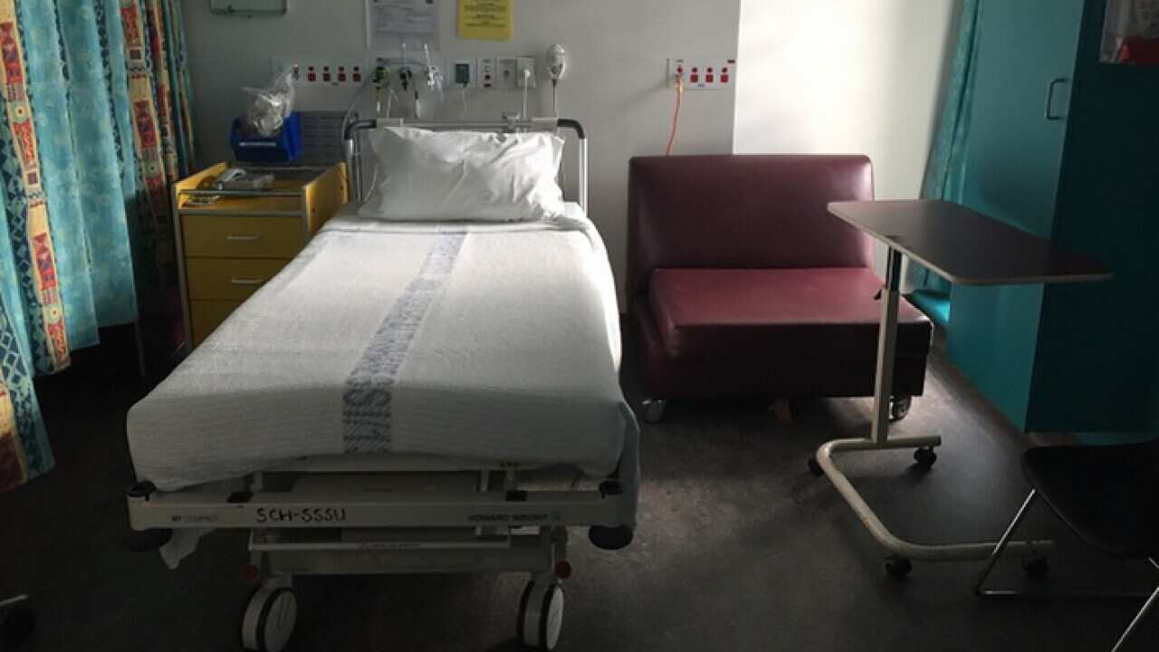 An empty bed in a hospital recovery room