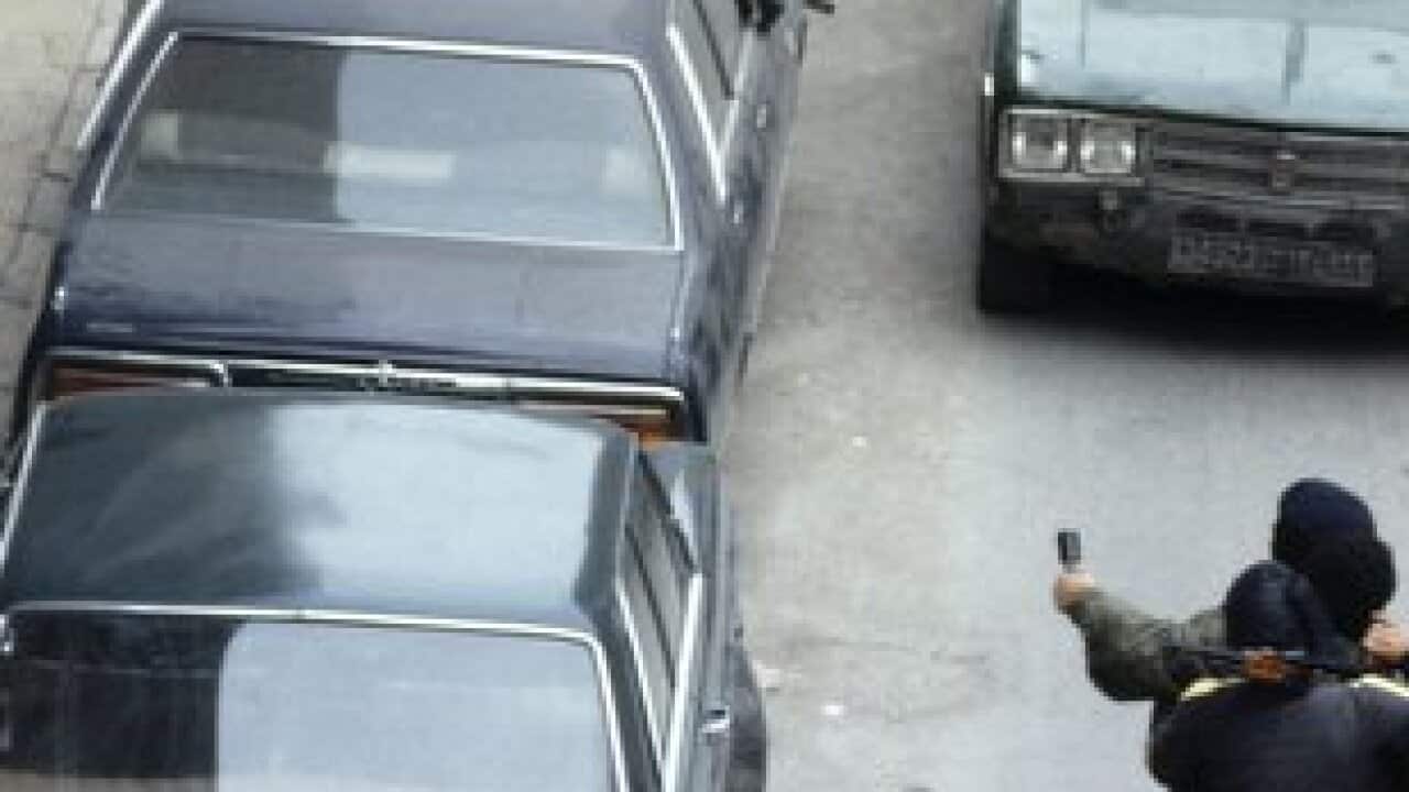 On a street in West Beirut, armed militiamen head for the '