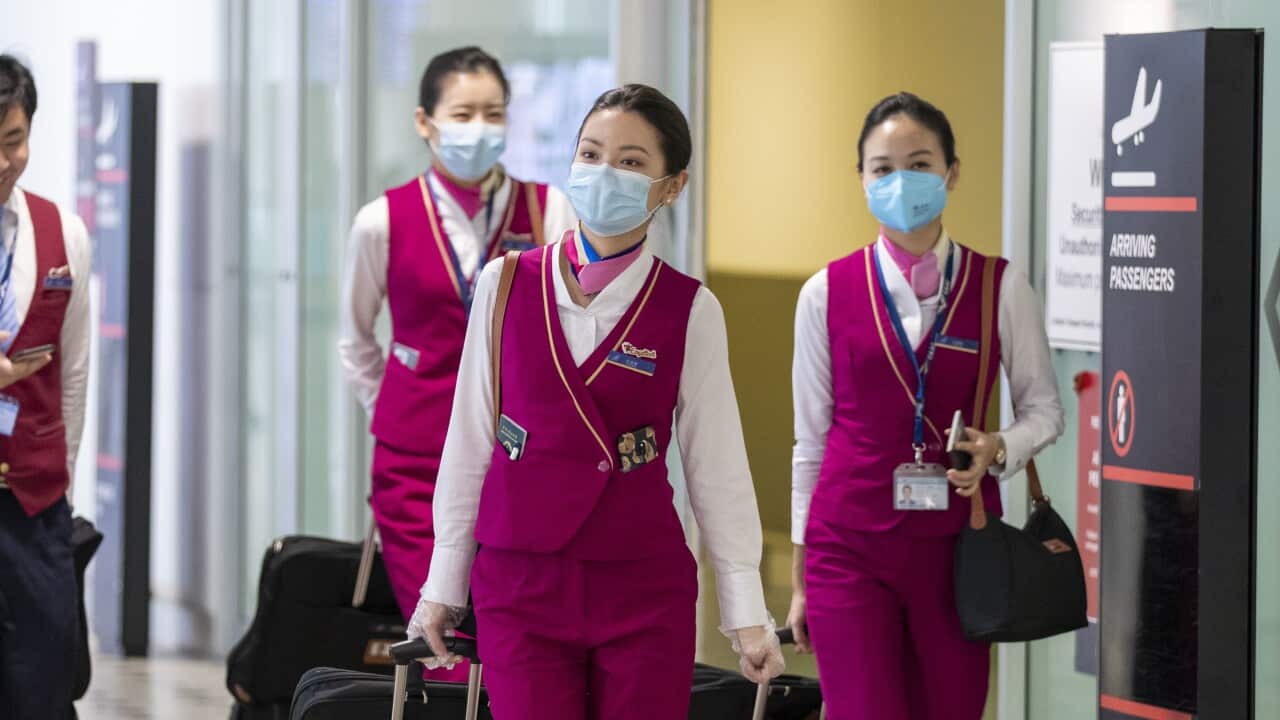 People wearing protective face masks to protect themselves from Coronavirus are seen at Brisbane International Airport.