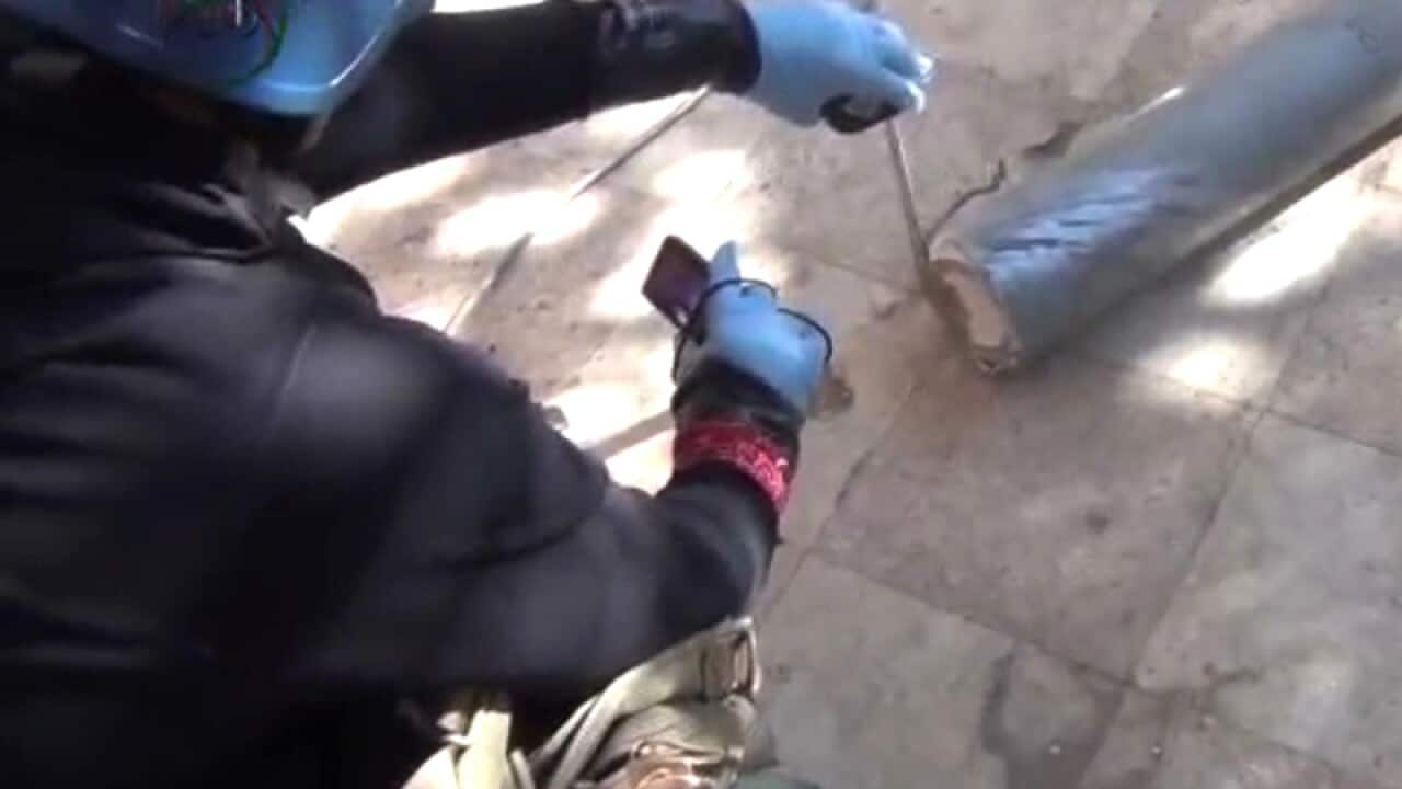 A UN staff member measuring a canister in Damascus