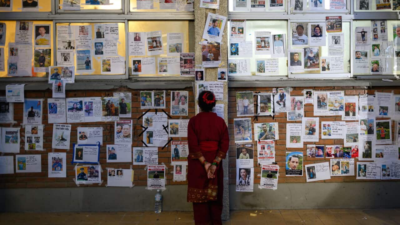 A woman looks at photographs of missing persons in the aftermath of flash floods, at the Tribhuvan University Teaching hospital in Kathmandu