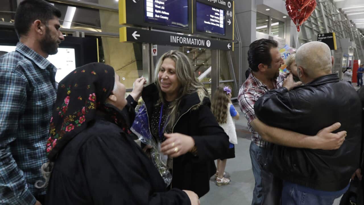 Refugees from Iraq embrace family members at San Diego