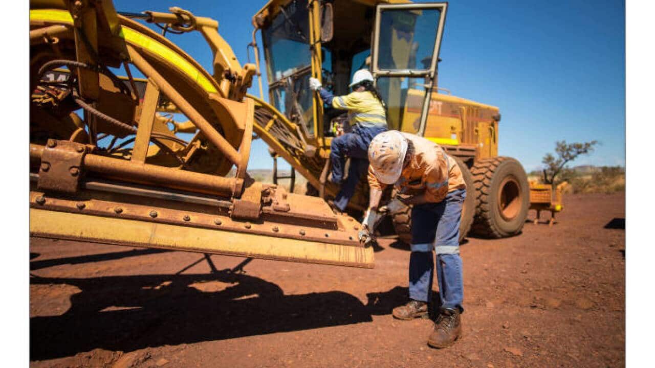 Indigenous workers carry out running repairs on giant machinery as part of their daily work at Christmas Creek mine in the Pilbara, Western Australia. Picture supplied
