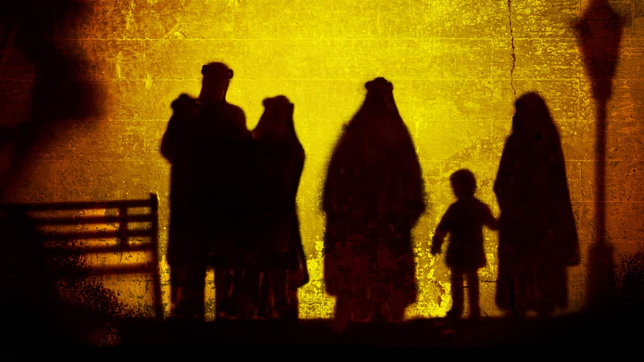 The outlines of a man, three women and a young child against an orange and yellow backdrop.