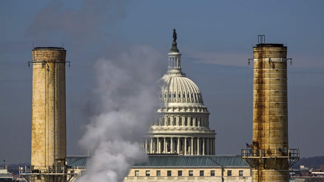 The dome of the US Capitol is seen behind the smokestacks of the Capitol Power Plant, the only coal-burning power plant in the nation's capital.