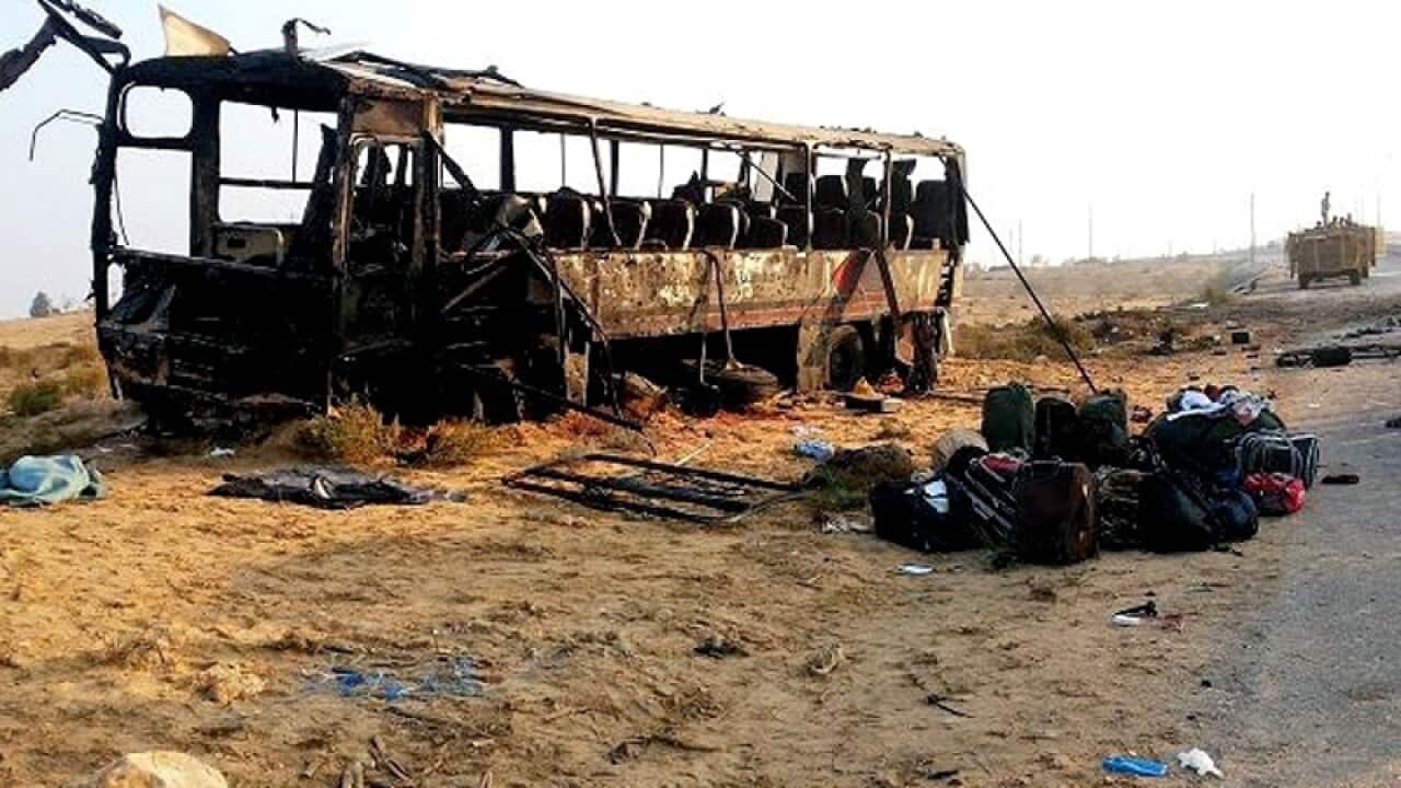 Egyptian military soldiers inspect the scene near a destroyed bus