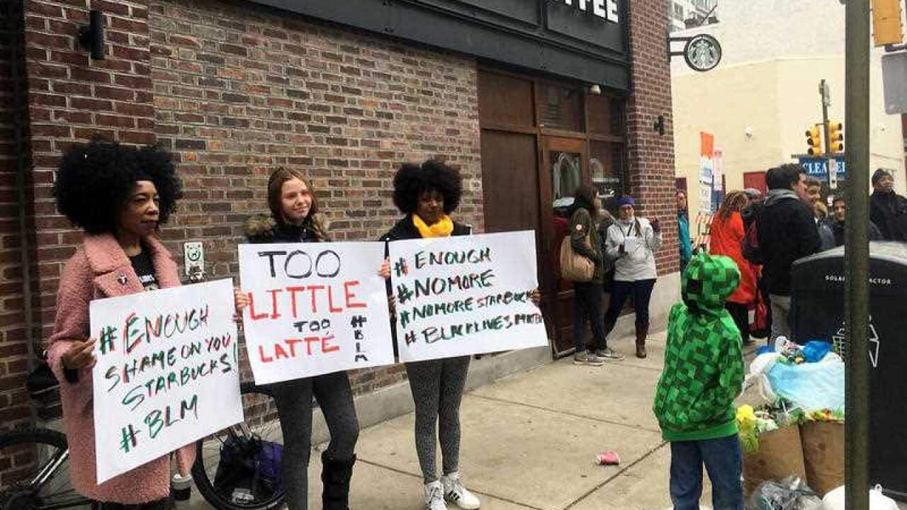 Demonstrators protest after two black men were arrested April 12, 2018, for sitting at a Starbucks cafe without ordering anything.