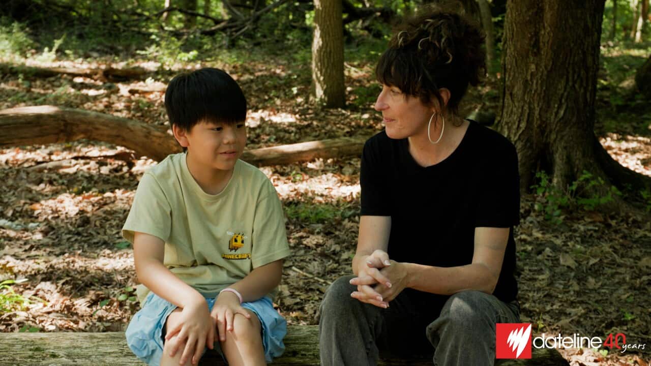 Asian American boy seated with Caucasian woman.