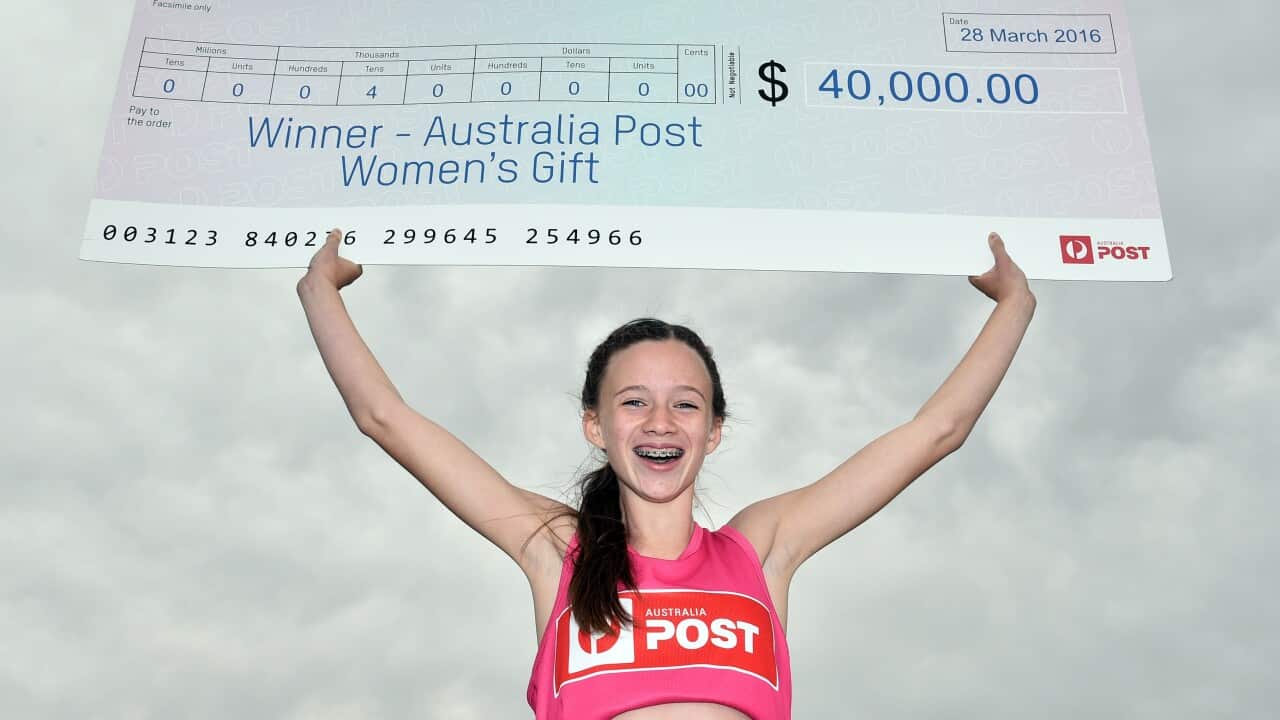 Fifteen-year-old Talia Martin poses with an oversized novelty cheque for $40,000 after winning the womens Stawell Gif (AAP)