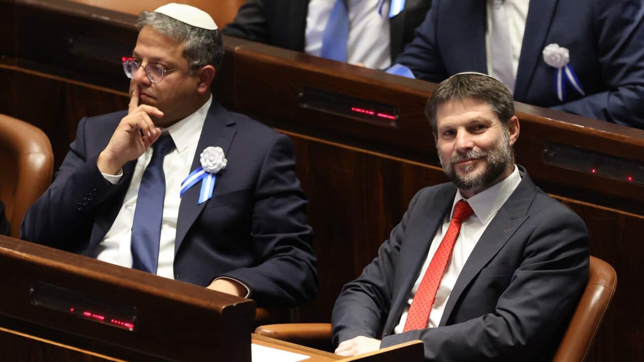 Two politicians wearing suits who are seated in Israel's parliament.