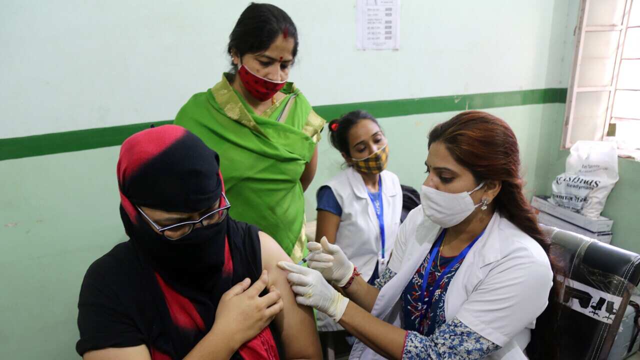 Health worker inoculates COVID-19 vaccine dose to young woman at city dispensary during mega vaccination drive on PM Narendra Modi's 71st birthday in Beawar.