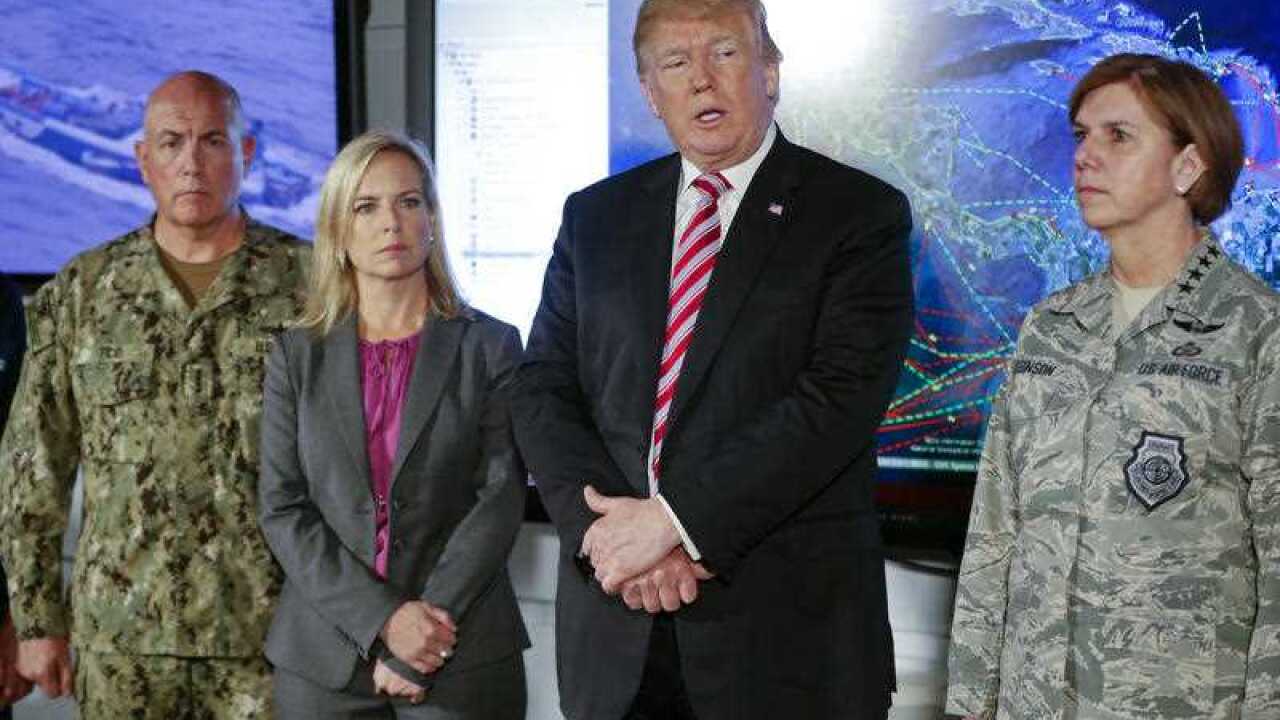President Donald Trump, center, speaks to members of the media during his visit to Joint Interagency Task Force South anti-smuggling center in Key West, Fla., Thursday, April 19, 2018.