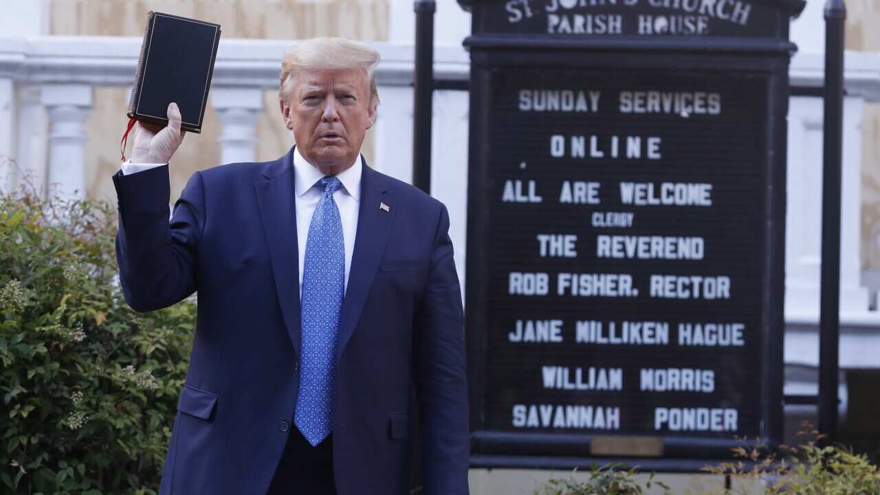 US President Donald J. Trump poses with a bible outside St. John's Episcopal Church after delivering remarks in the Rose Garden.