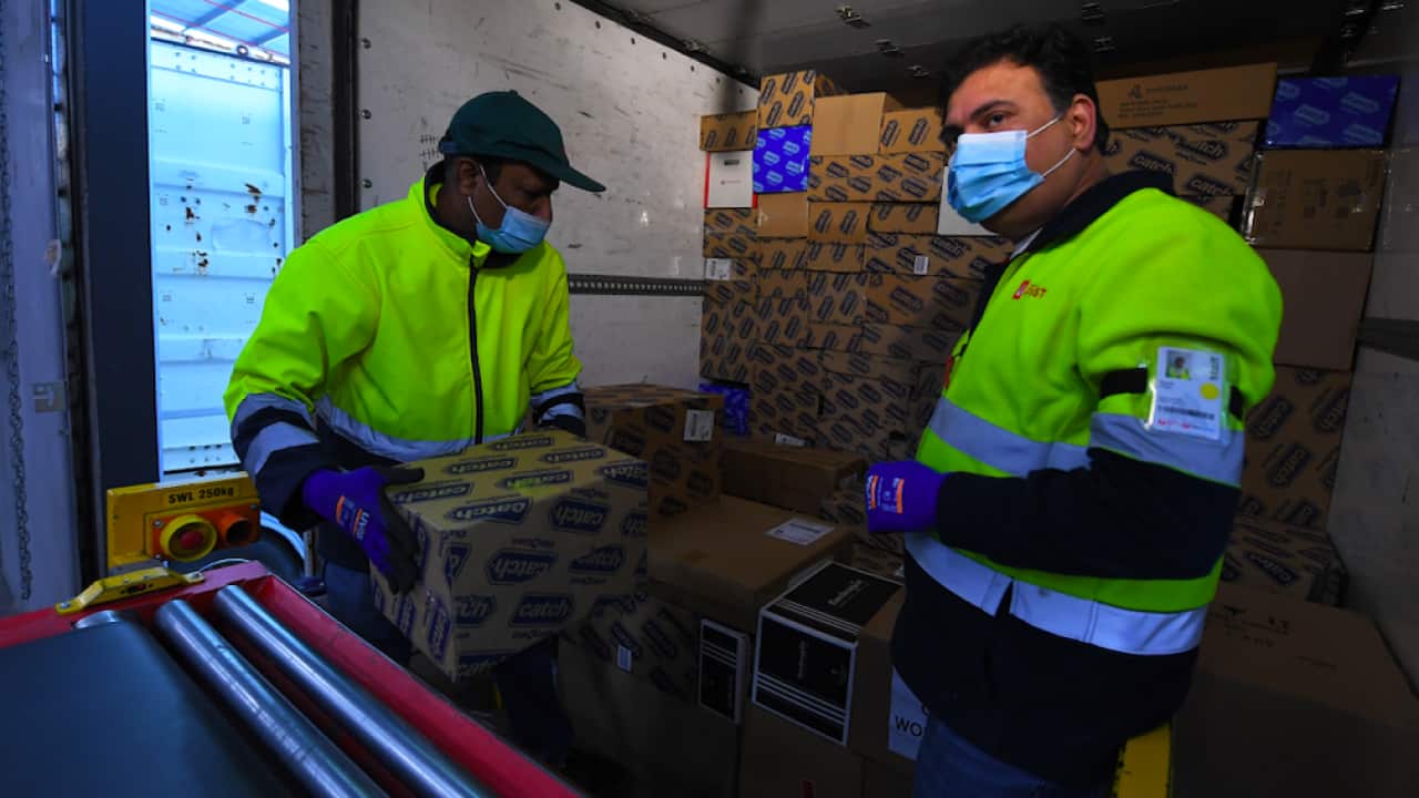 Employees load parcels into a delivery truck at Australia Post’s Sunshine West Parcel Delivery Centre in Melbourne, 16 November 2021.