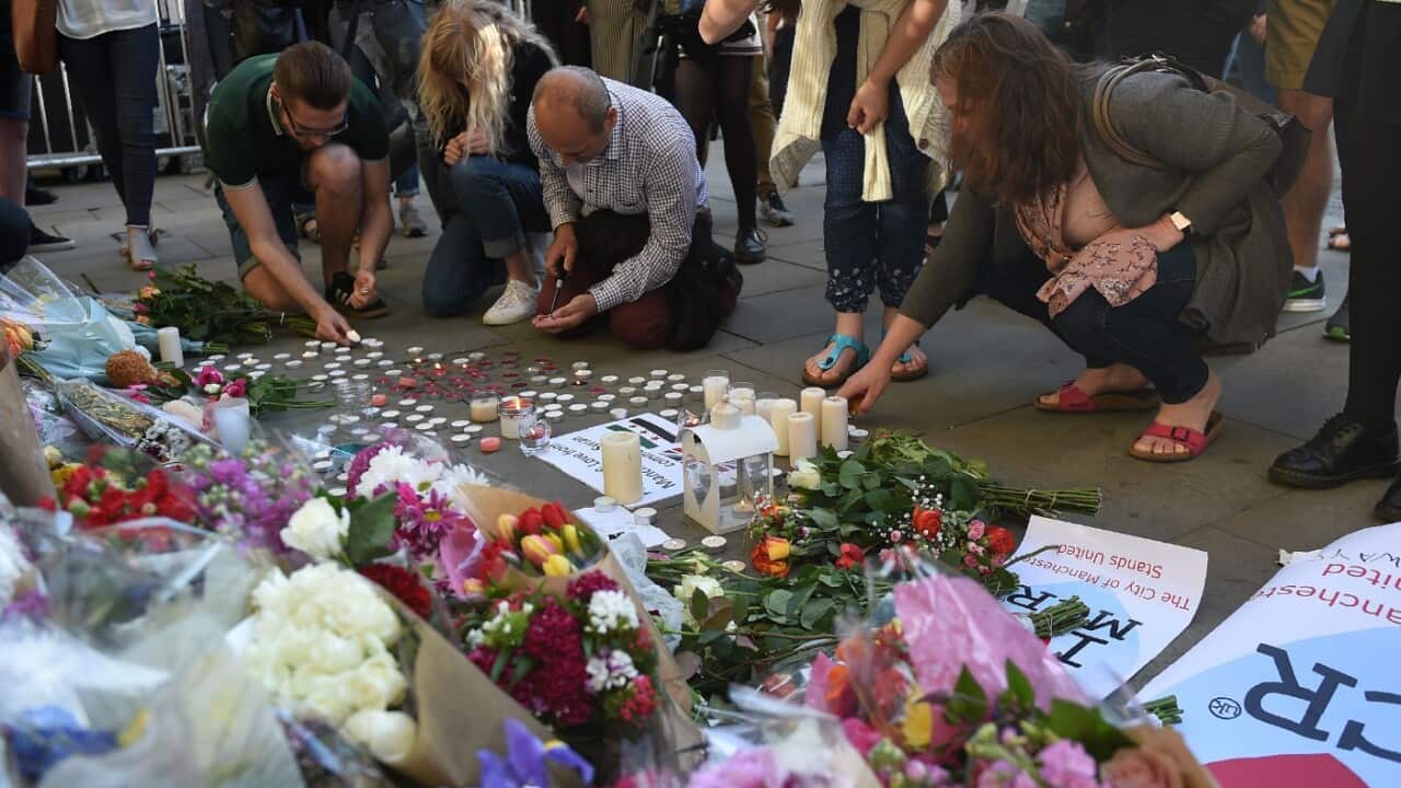 People light candles in front of floral tributes at a vigil in Albert Square in Manchester, northwest England on May 23, 2017
