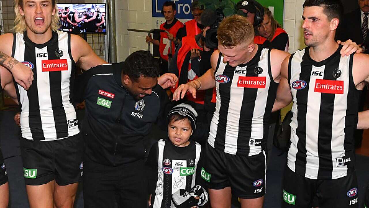 Kyron McGuire Senior and Kyron McGuire join Darcy Moore, Adam Treloar and Scott Pendlebury of the Magpies in the circle as they sing the song after thier win.