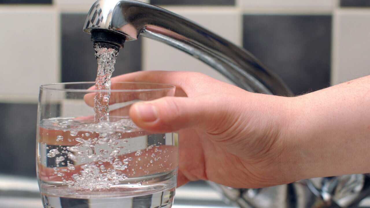 Tap water being poured from a tap in to a glass.