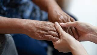 Hand of elderly woman holding hand younger woman