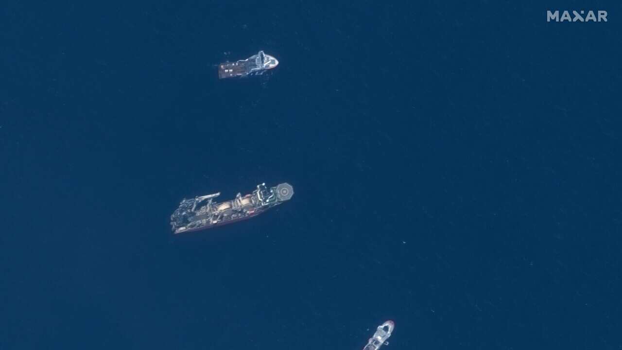 A birds-eye view of three large ships on the ocean's surface.