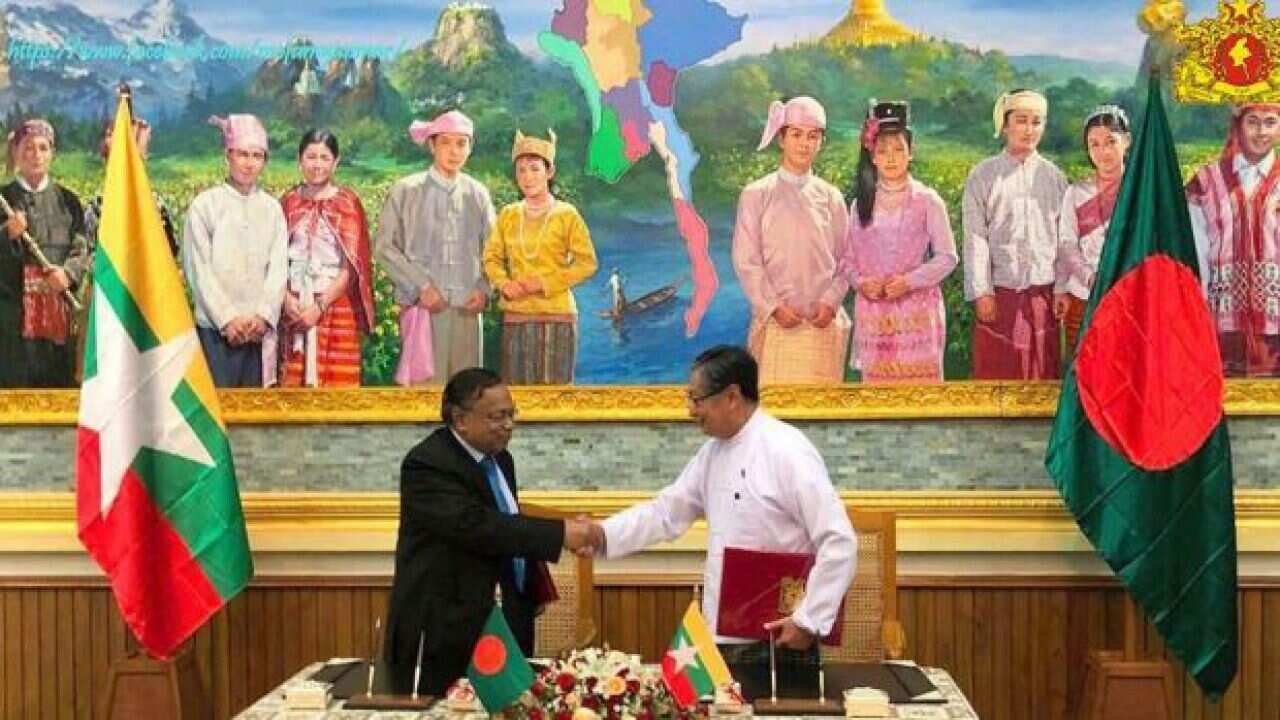 Bangladesh’s Abul Hassan Mahmood Ali and Myanmar’s Kyaw Tint Swe exchange documents in Naypyitaw, Myanmar.