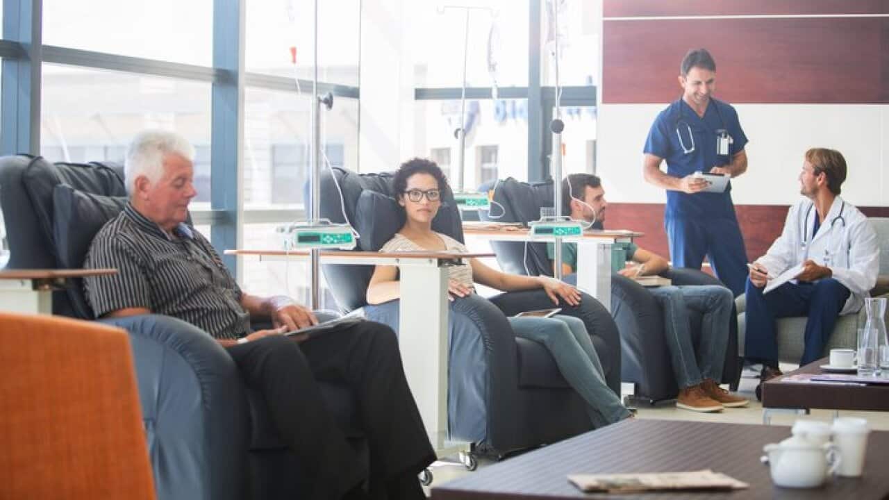 Patients undergoing medical treatment with doctors discussing in outpatient clinic