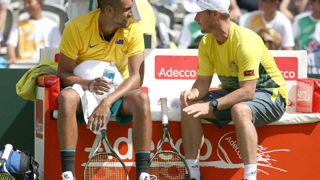 Australia's Nick Kyrgios (L) speaks with team captain Lleyton Hewitt