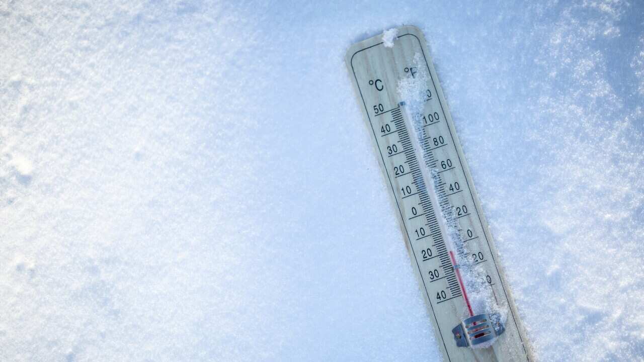The thermometer on the snow shows low temperatures well below zero. Extreme winter freezing weather.