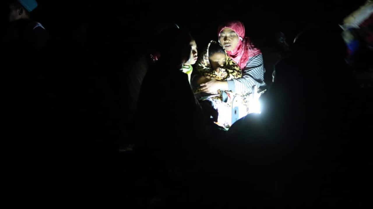 A mother holds her son during aftershocks in Lombok