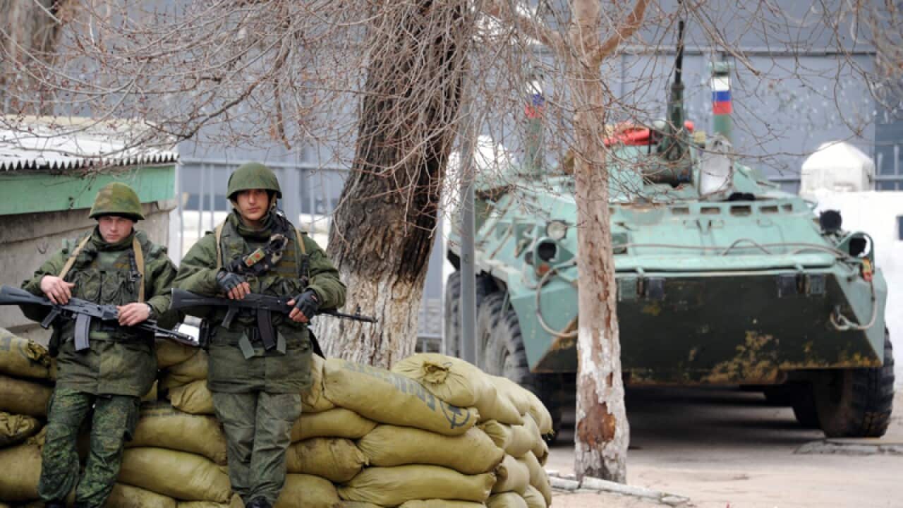 Russian soldiers guard a landing ship anchored in Sevastopol