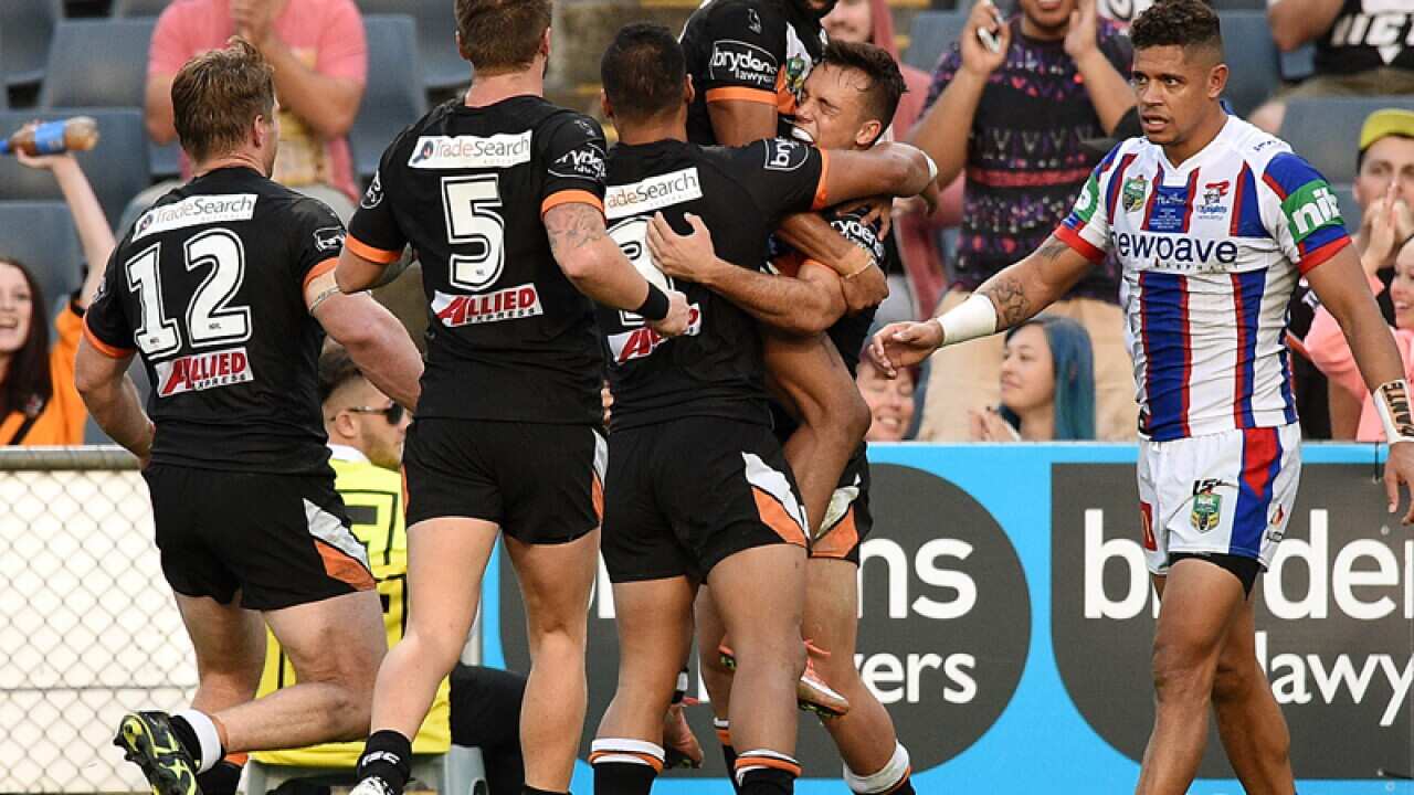 Luke Brooks of the Tigers, (second right), celebrates with team mates
