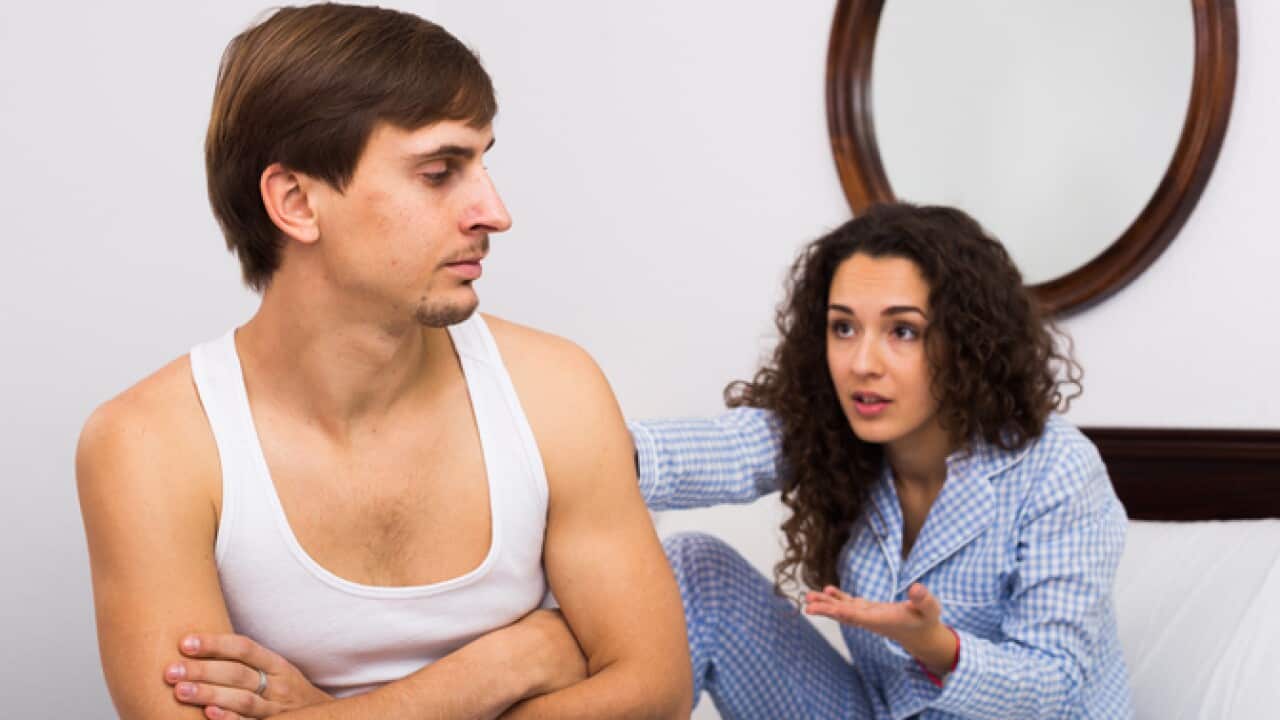 Upset husband and angry wife in bed