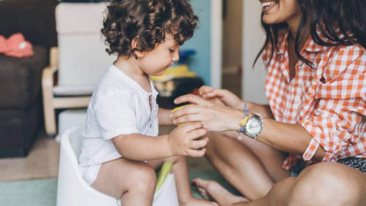 Mother training her toddler to use the potty