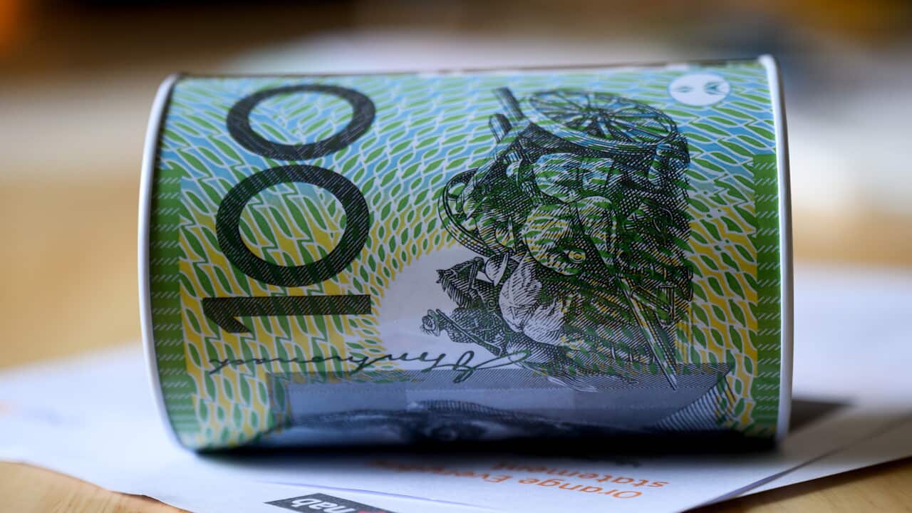 A coin tin with a $100 note printed on it.