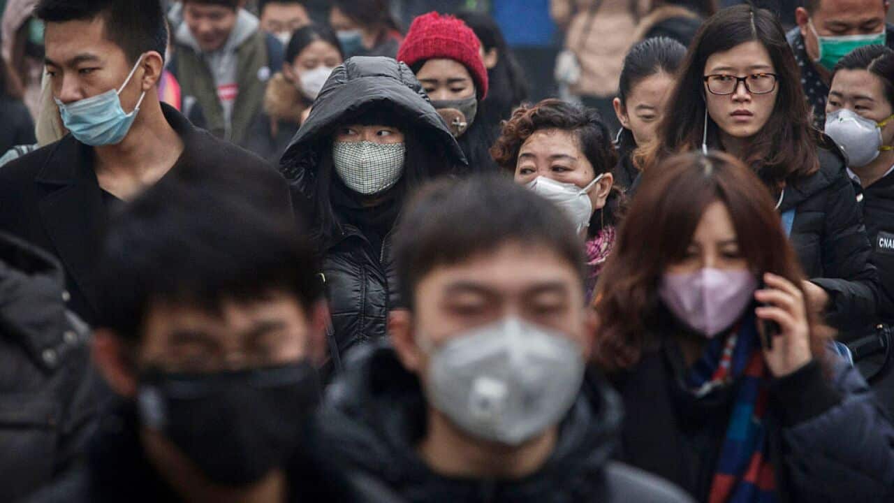 Chinese commuters, many wearing mask, walk to work during heavy pollution on December 9, 2015 in Beijing