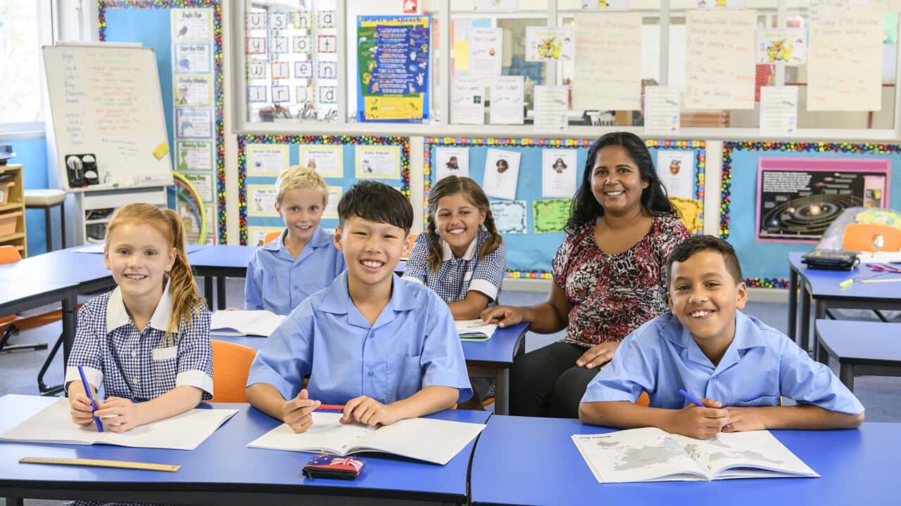 Portrait of five primary school children in classroom with their teacher