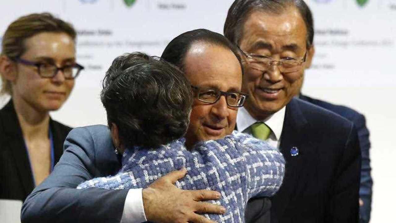 United Nations Secretary General Ban Ki-moon, right, watches French President Francois Hollande hugging United Nations climate chief Christiana Figueres