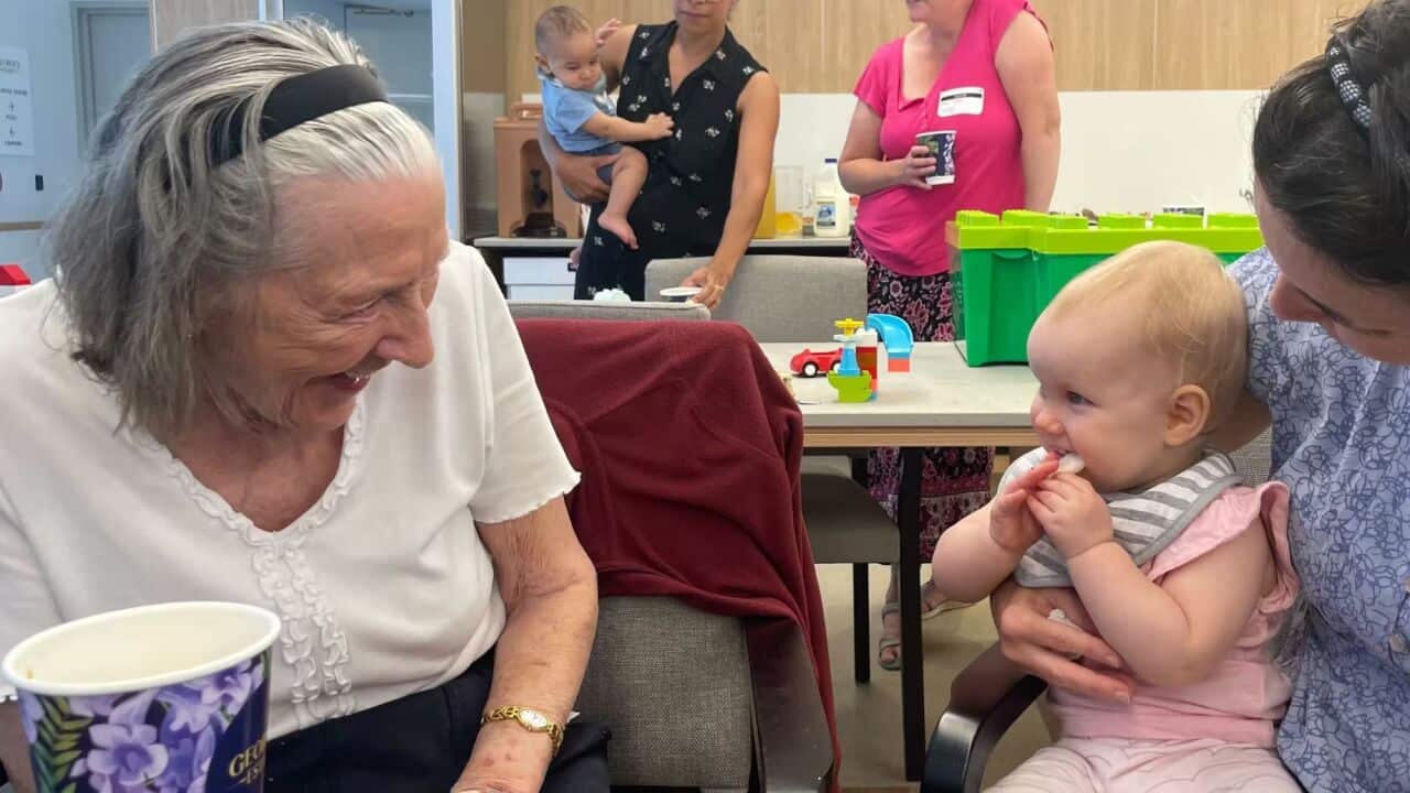 Residents at aged care facility enjoy time with children during a playgroup session