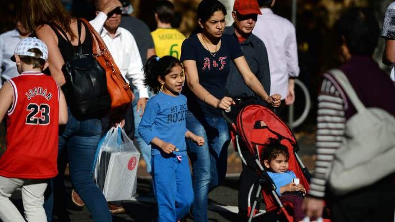 People cross a street in Sydney