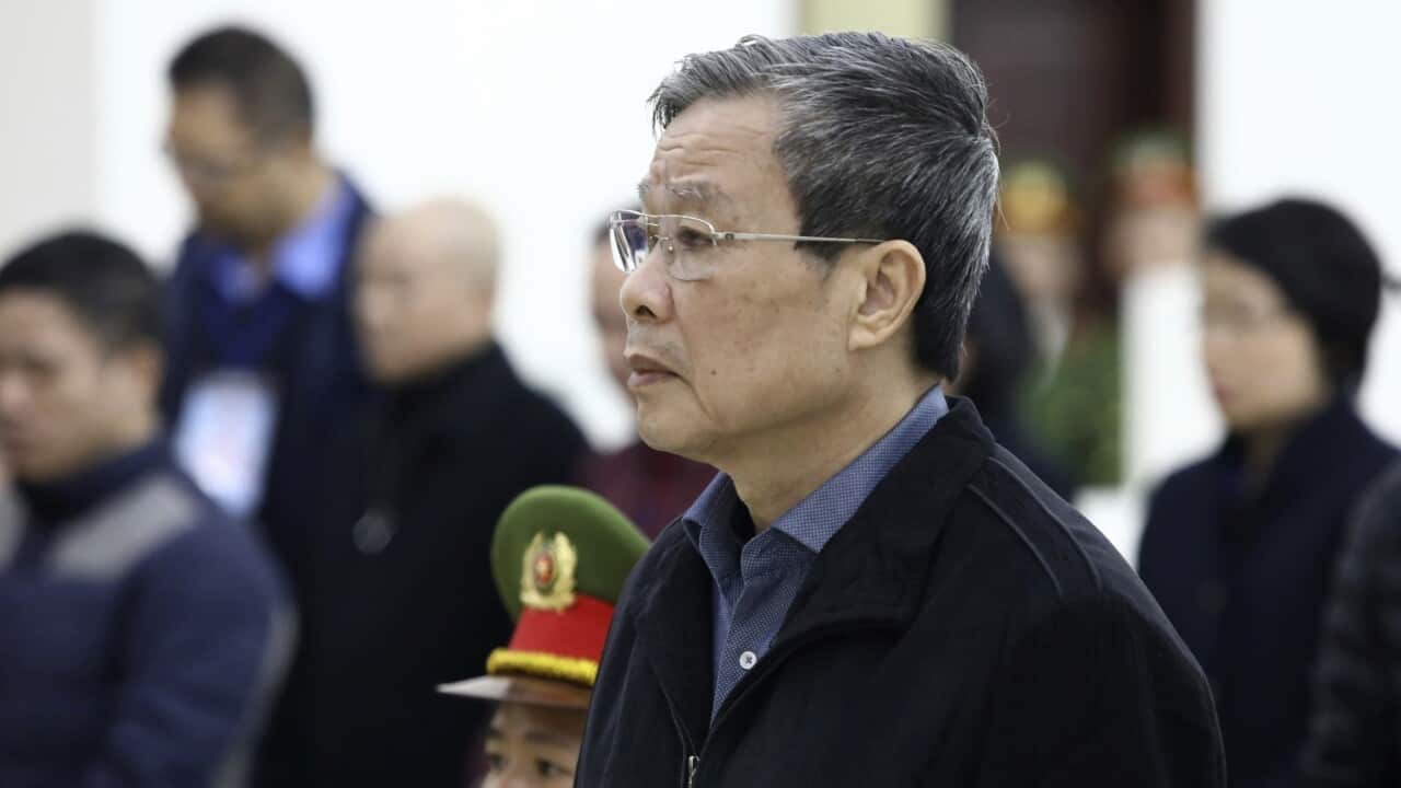 Ex-minister of information and communication Nguyen Bac Son stands as judge reads the verdicts at his trial in Hanoi, Vietnam.