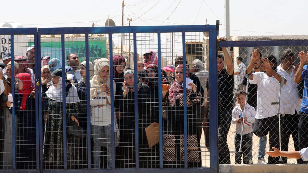 Syrian refugees wait for their turn to enter services facility area at the Zaatari refugee camp, Jordan.