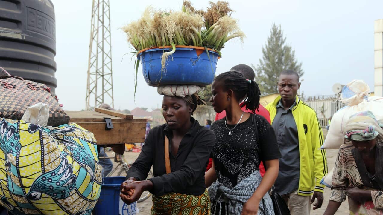 People wash their hands at the border between Congo and Rwanda.