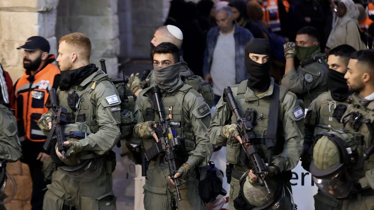 Israeli police carrying weapons patrol Al-Asqa Mosque.